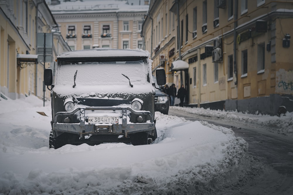 auto nera sulla strada coperta di neve durante il giorno