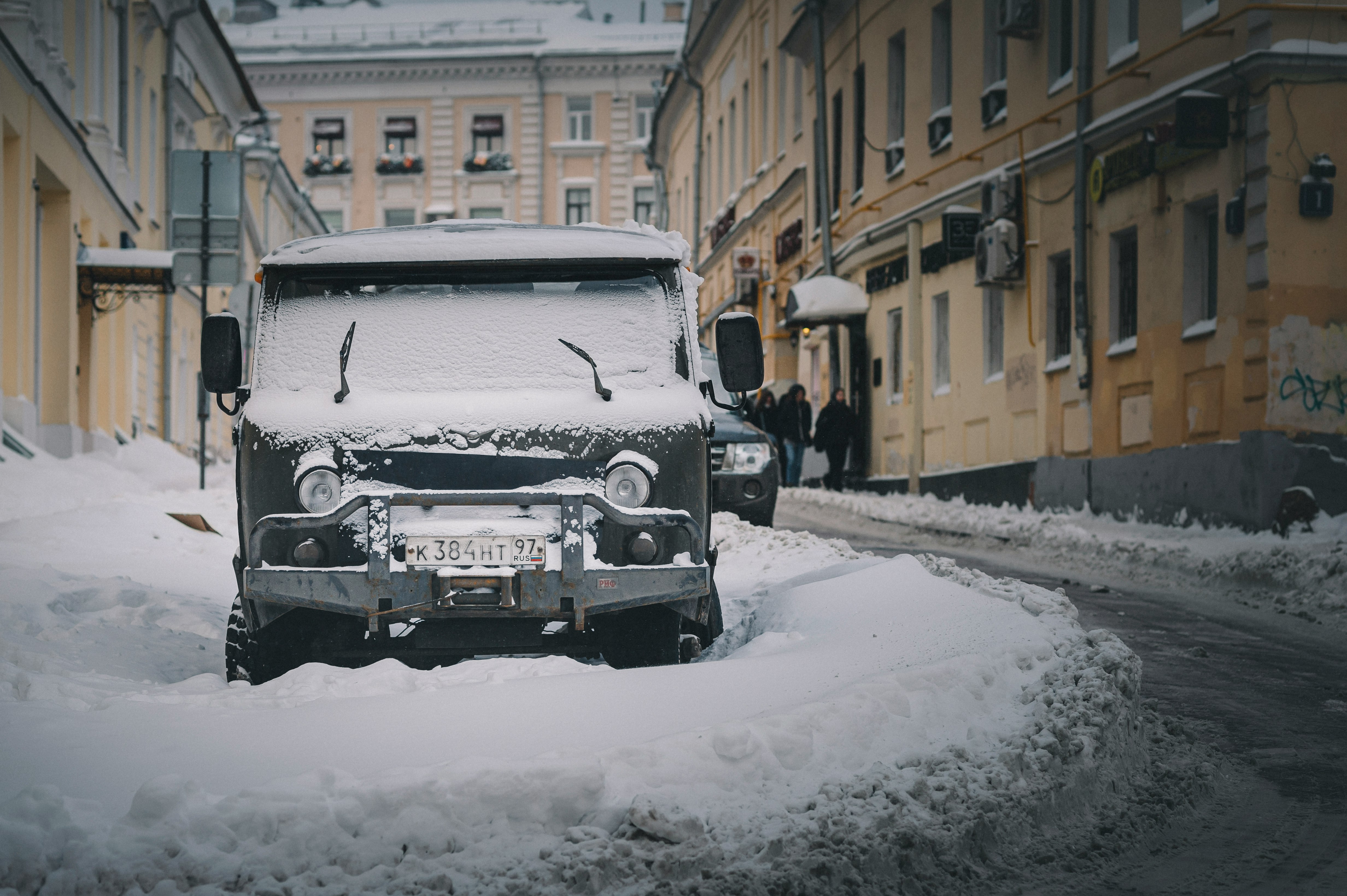 black car on snow covered road during daytime