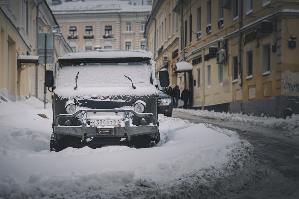 Schwarzes Auto tagsüber auf schneebedeckter Straße