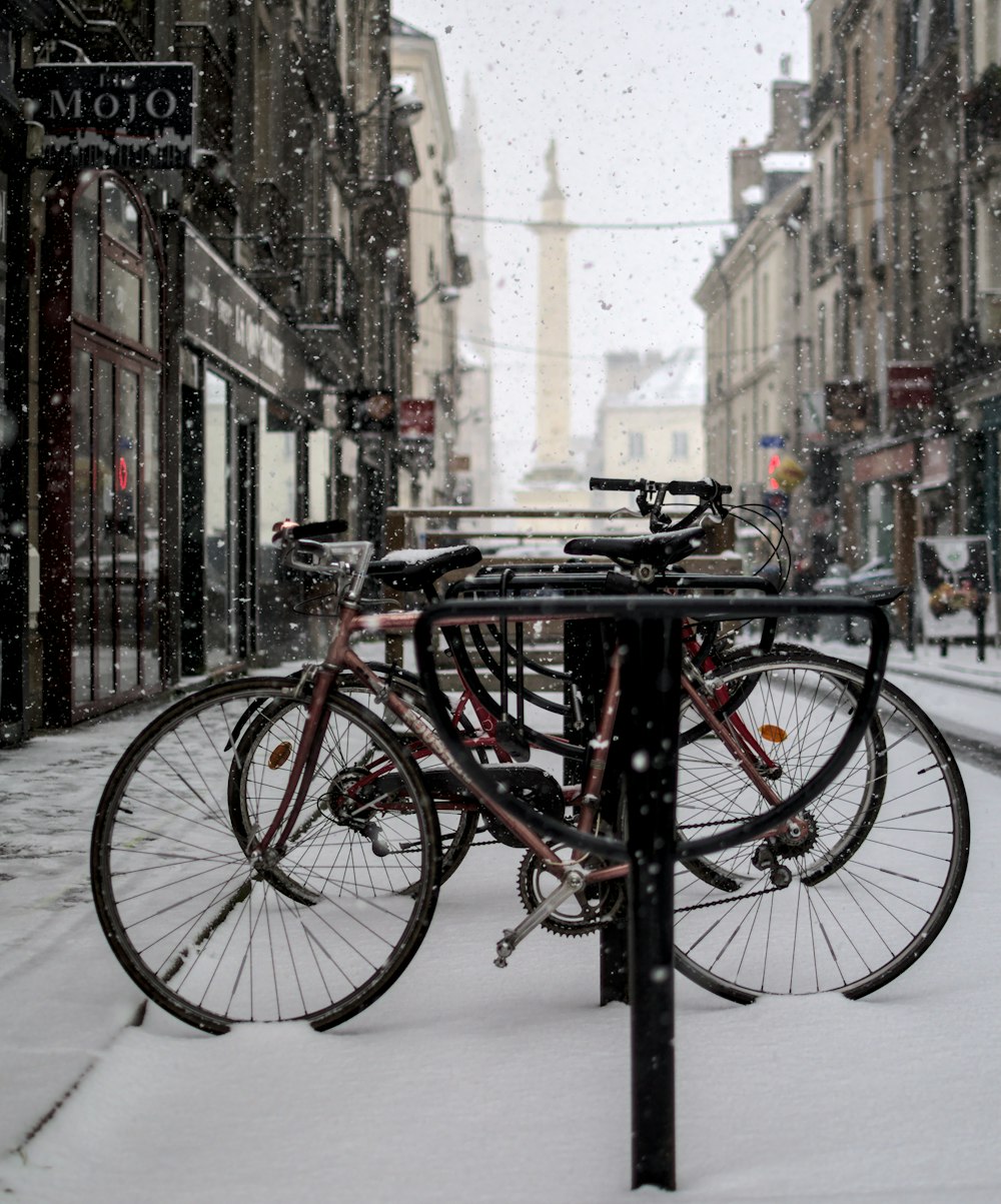 red and black city bike parked on sidewalk during daytime