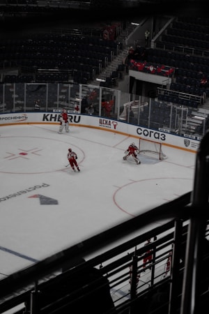 Hockey players battling for the puck along the boards during an indoor ice hockey game