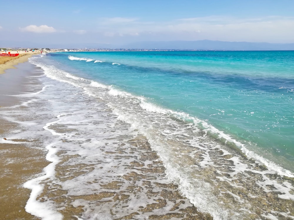 sea waves crashing on shore during daytime