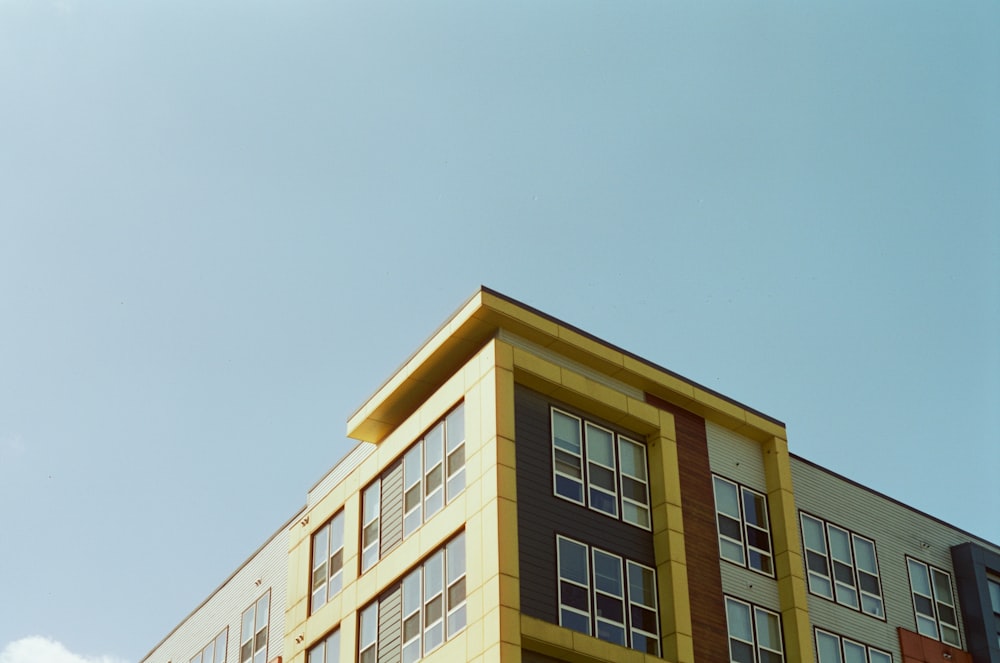 Bâtiment en béton beige sous ciel bleu pendant la journée