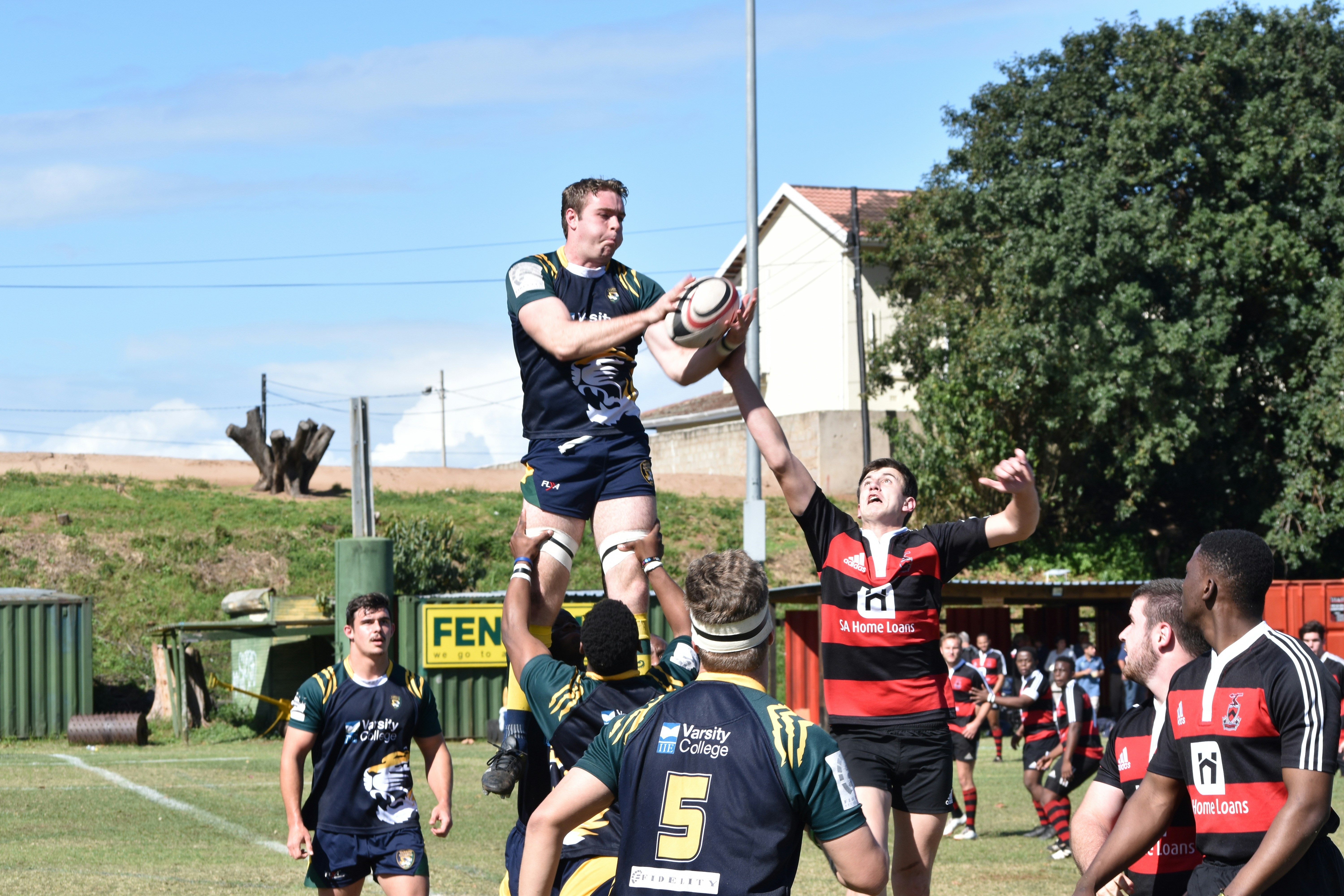 Young men playing rugby and catching the ball in the line-out. Lock lifting a jumper high into the air.