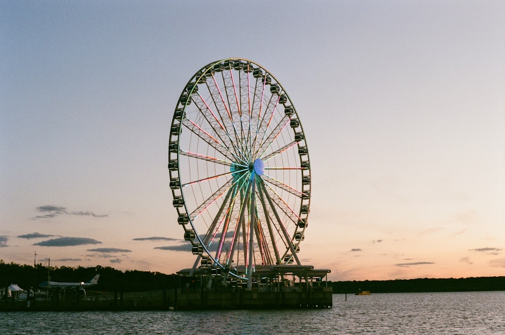 ferris wheel near body of water during sunset