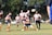 group of people playing soccer on green grass field during daytime