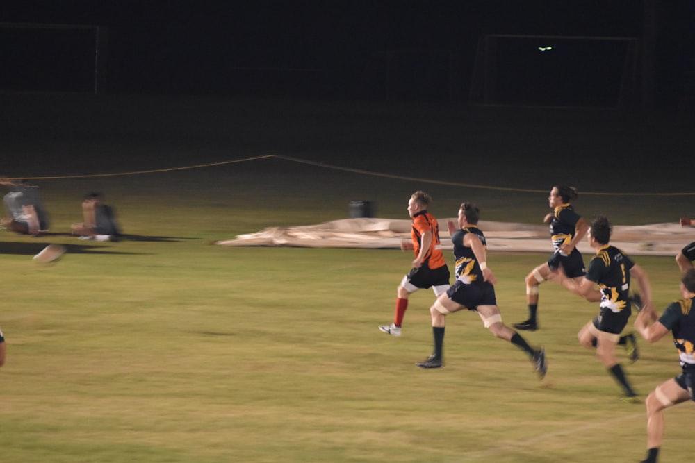 2 men playing soccer on field during night time