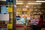 woman in pink polo shirt standing in front of store