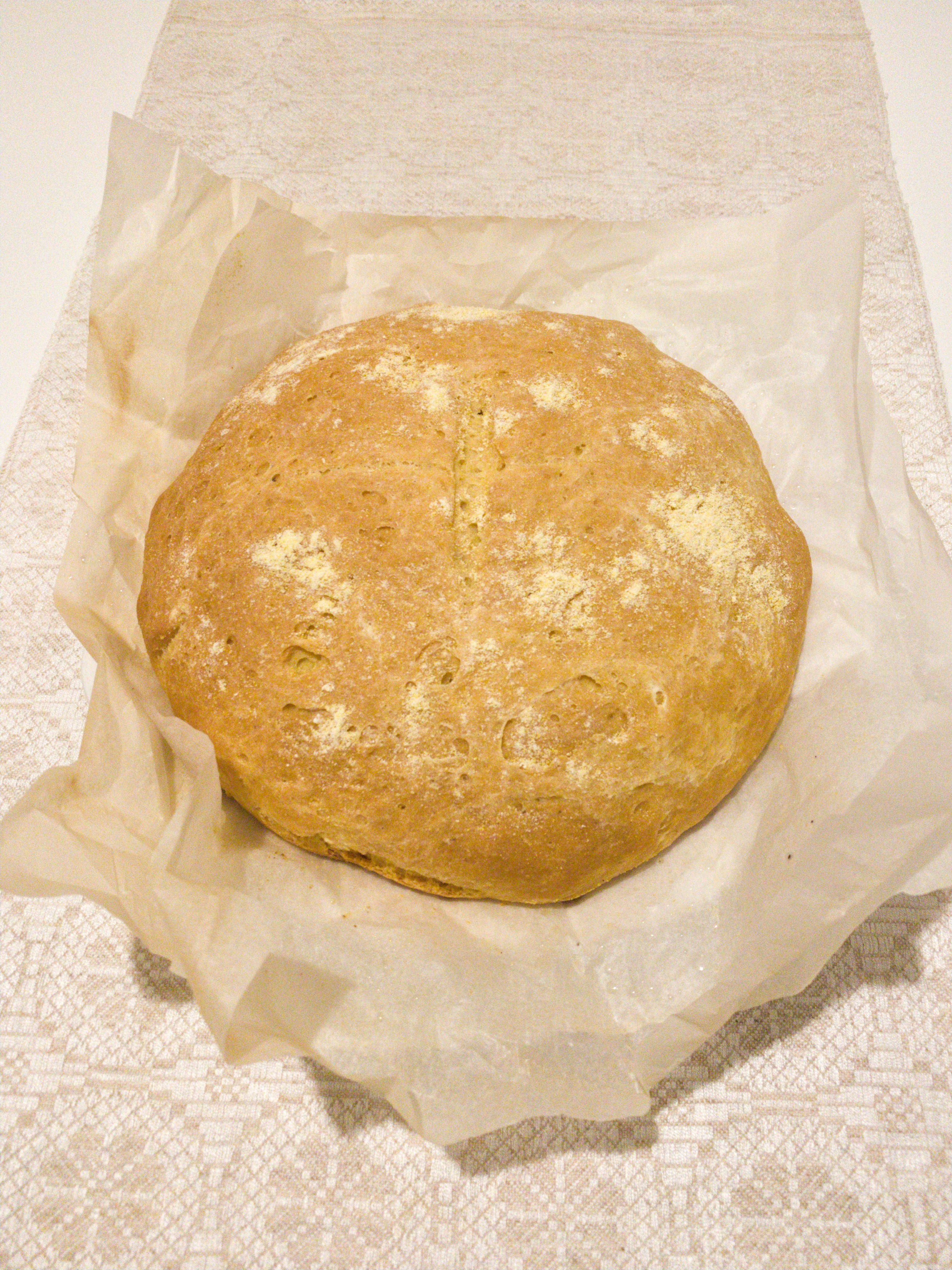 Freshly baked quarter loaf bread sliced open showing soft white interior, warm kitchen lighting, dark background