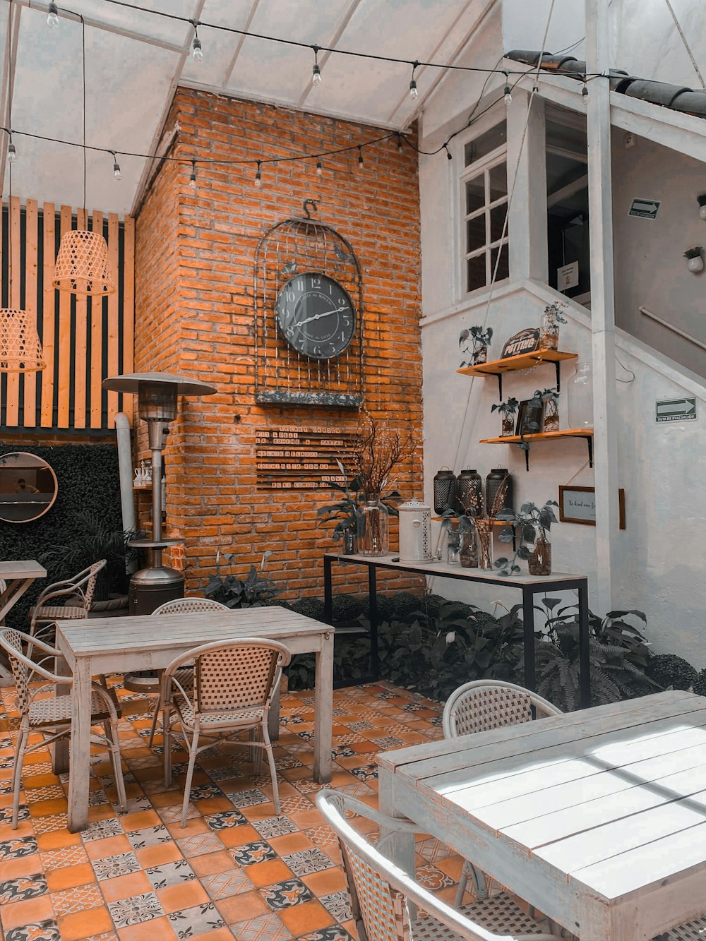 black metal chairs and table near brown brick wall