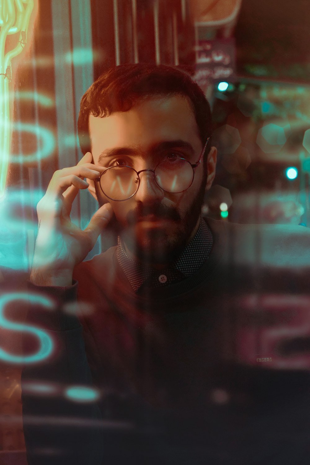 homme avec des lunettes à monture noire et une chemise boutonnée noire