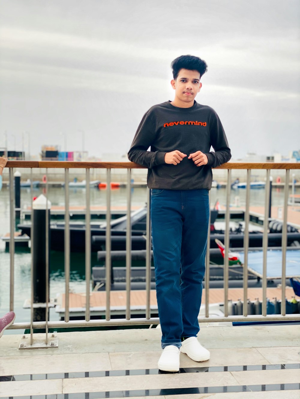 man in black hoodie standing on white wooden dock during daytime