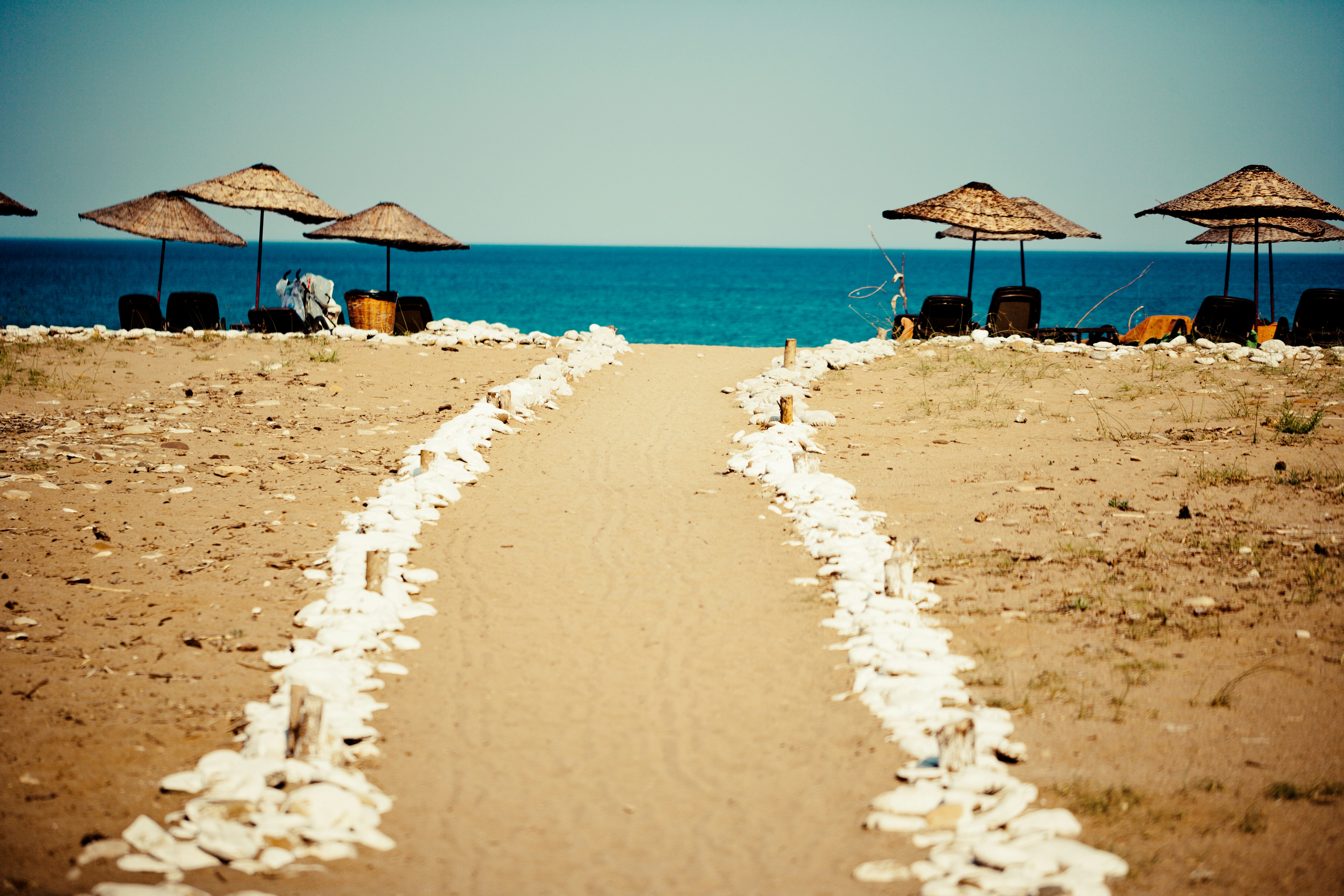 brown beach umbrellas on beach during daytime