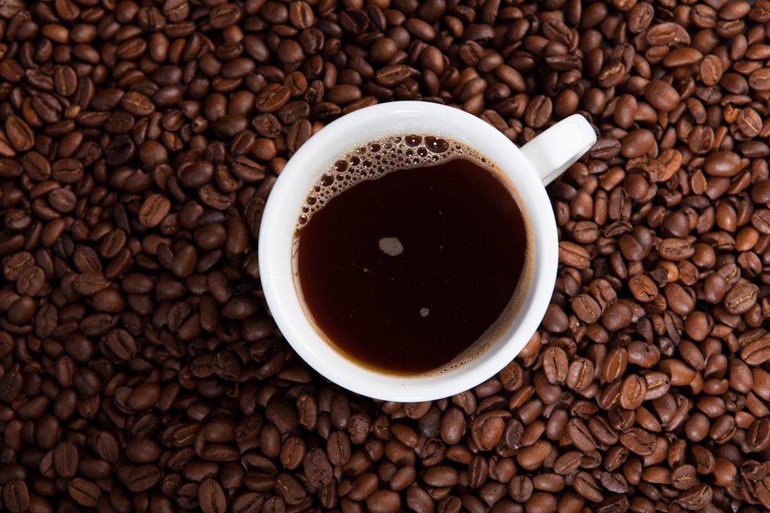 white ceramic mug on coffee beans