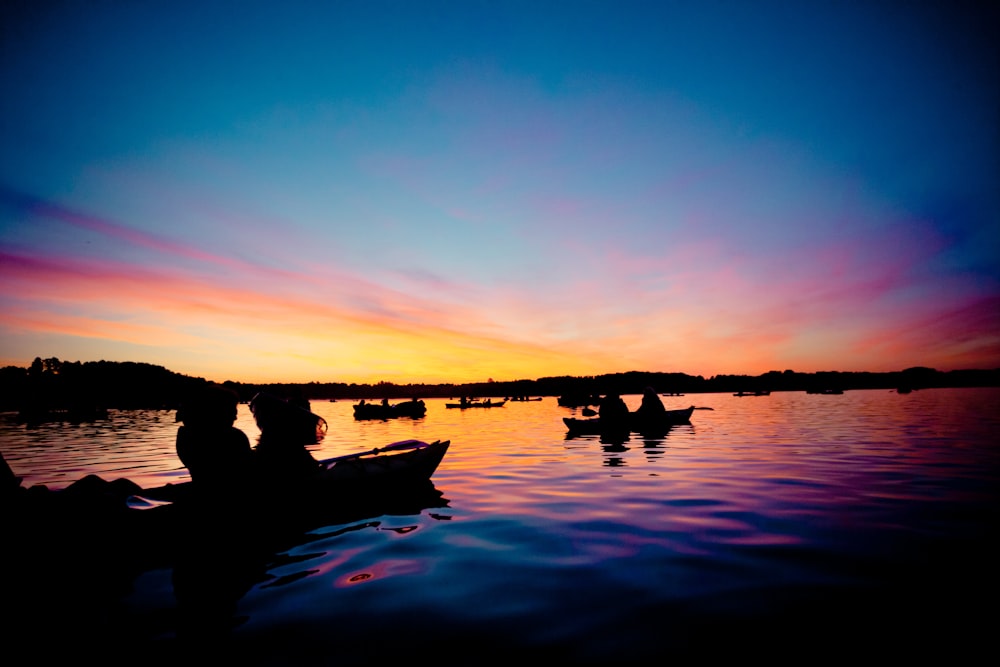 silhueta das pessoas no barco durante o pôr do sol