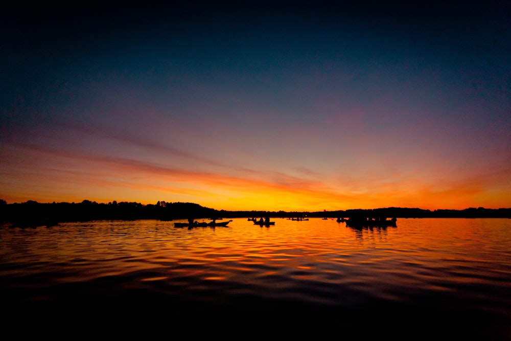 silhouette of people riding horses during sunset