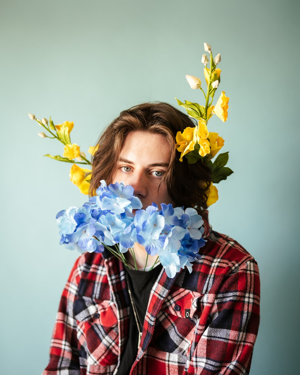 woman in red white and black plaid dress shirt holding yellow flower bouquet