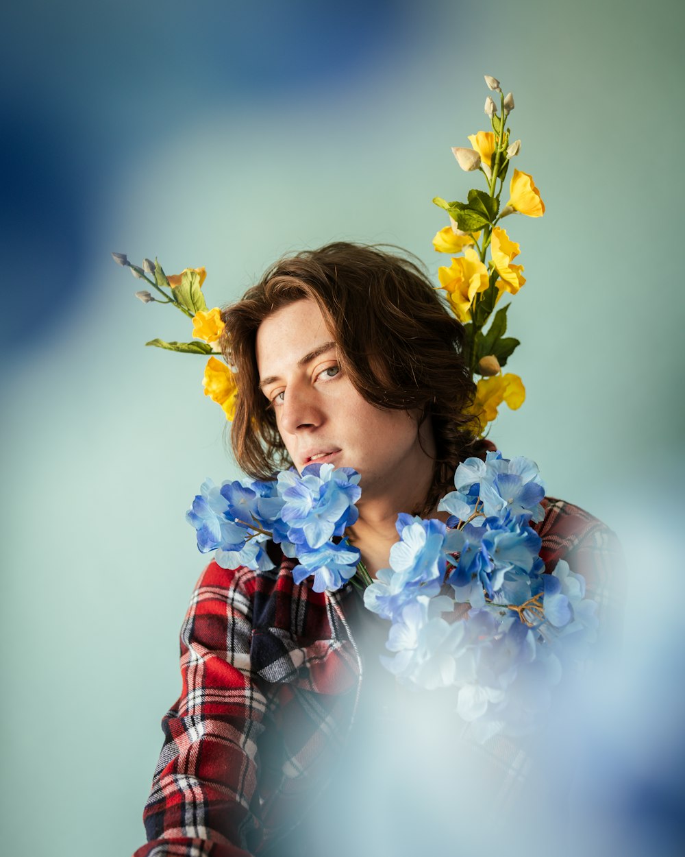 woman in red and white plaid dress shirt holding yellow flowers