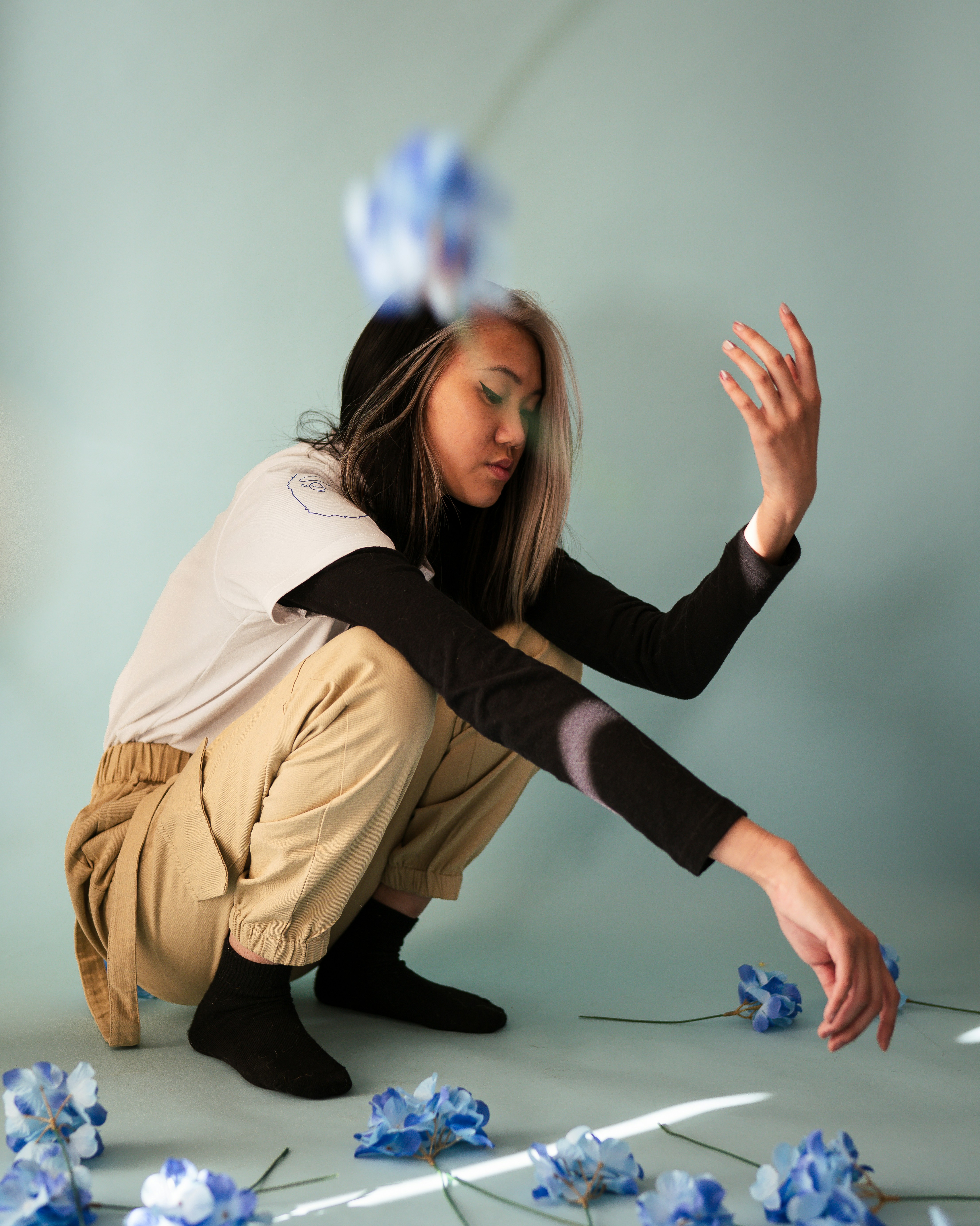 woman in brown jacket and black pants sitting on floor