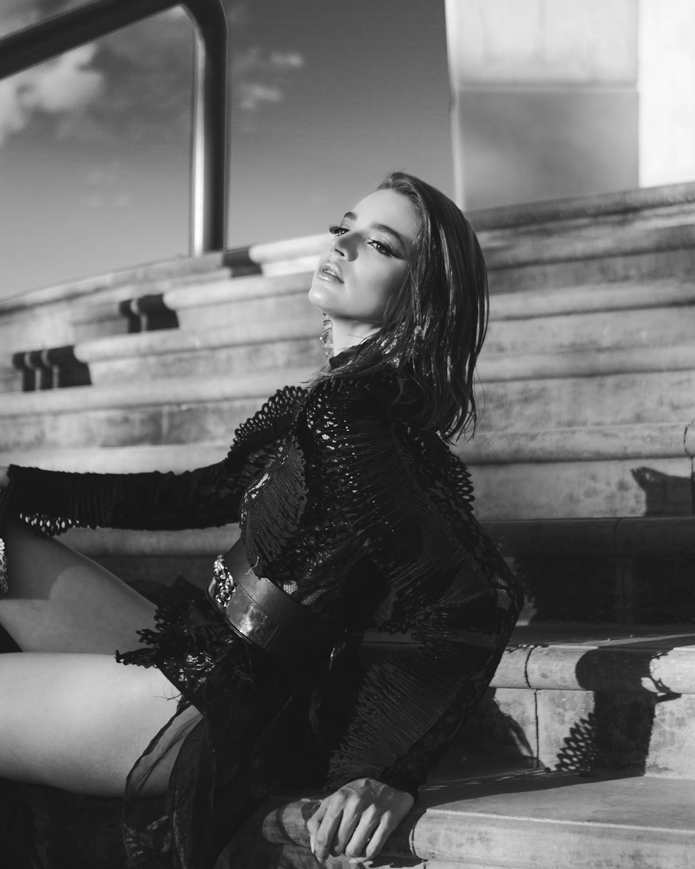 woman in black and white long sleeve shirt sitting on concrete bench