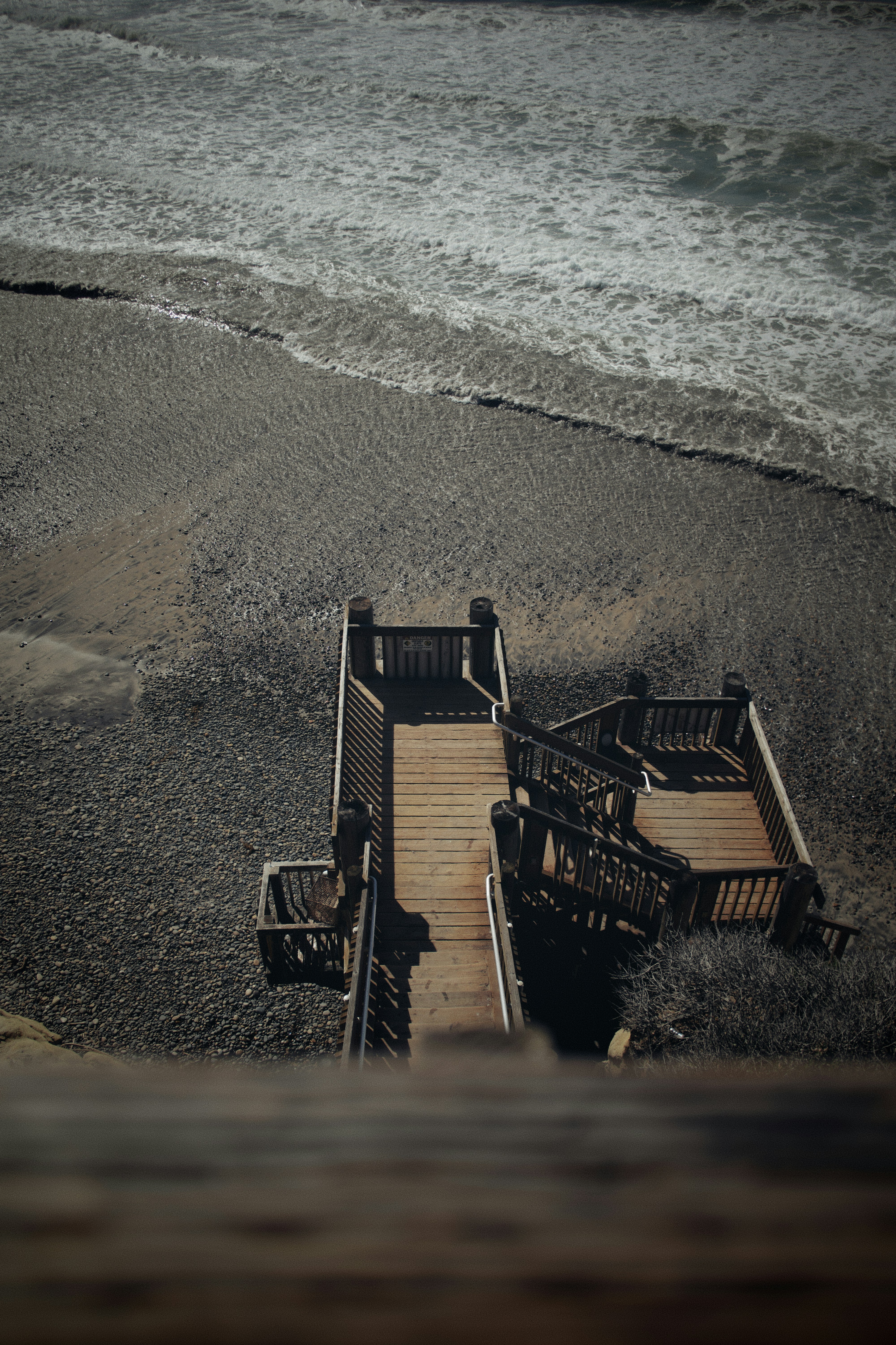 brown wooden chairs on beach shore during daytime