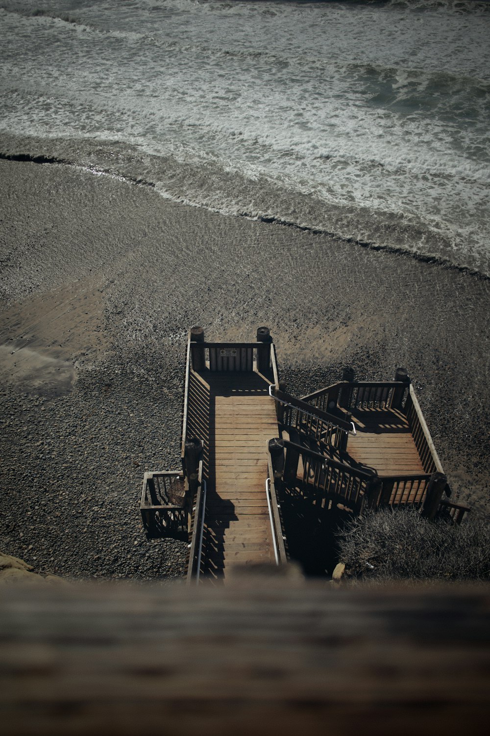 brown wooden chairs on beach shore during daytime