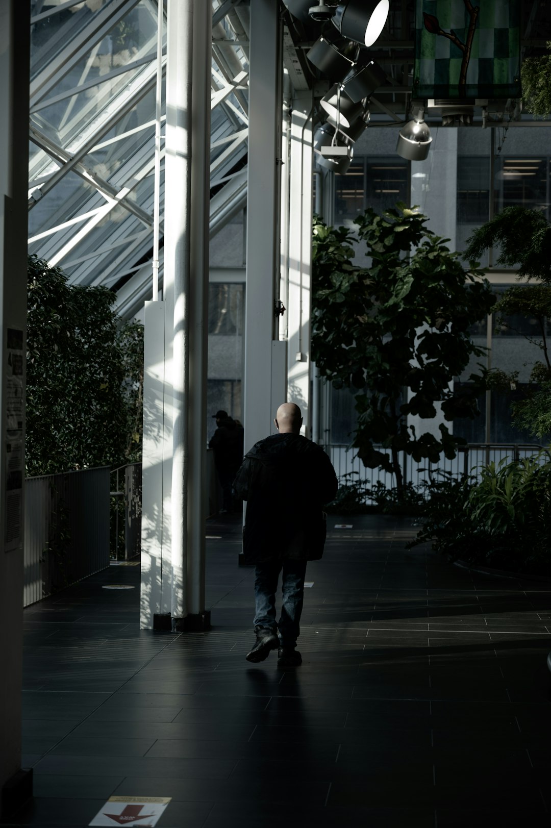 man in black jacket walking on hallway