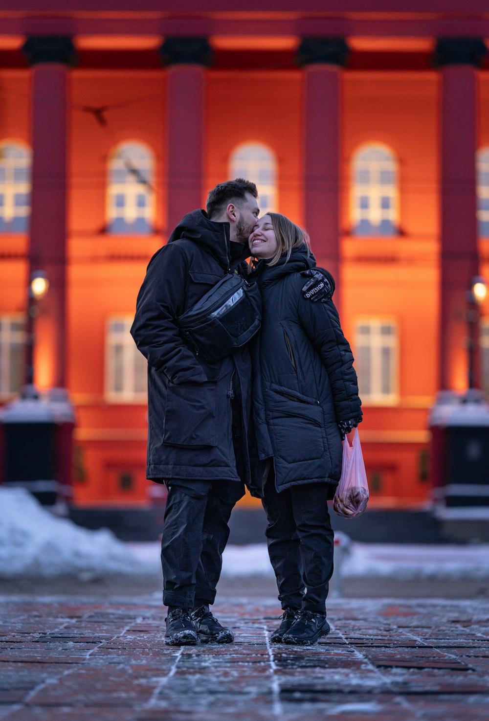 um homem e uma mulher em pé na frente de um edifício