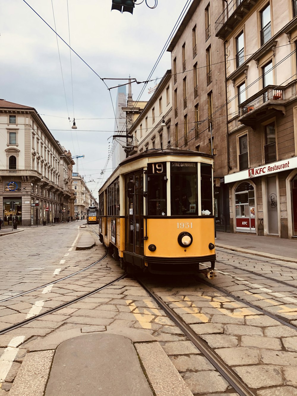 yellow and white tram on street during daytime