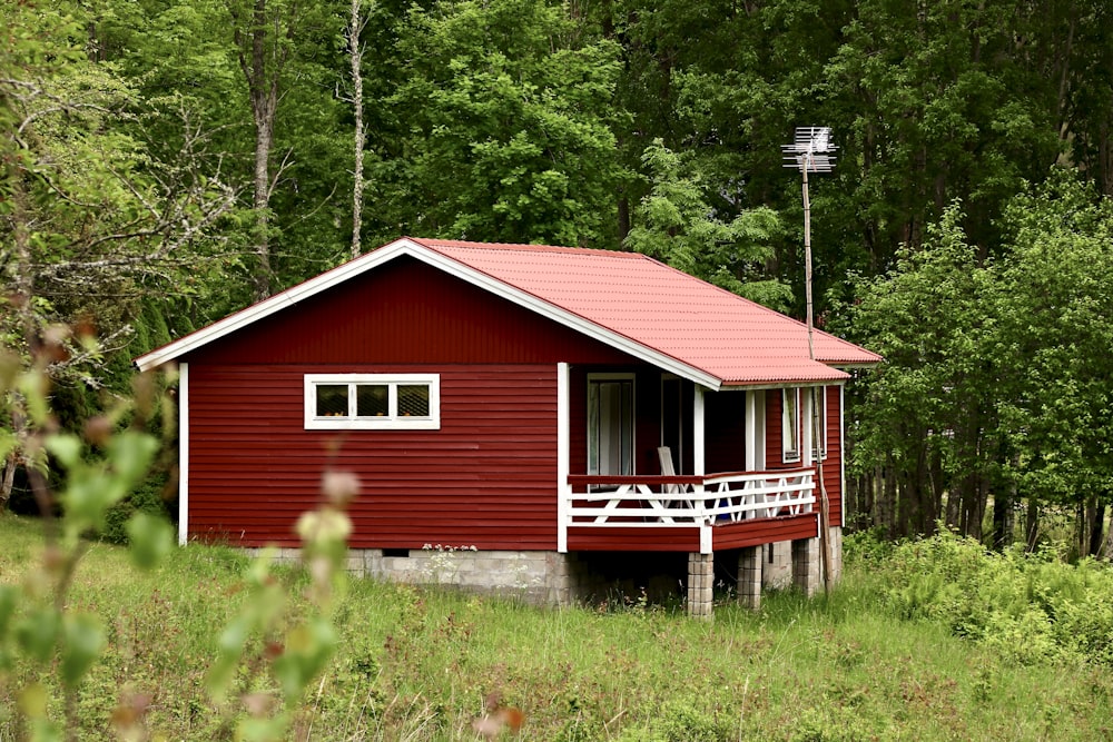 red and white wooden house surrounded by green trees during daytime