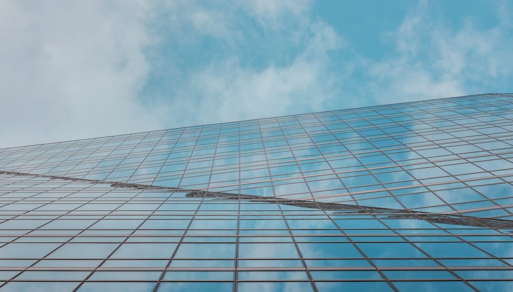 blue and white glass walled building under blue and white cloudy sky during daytime