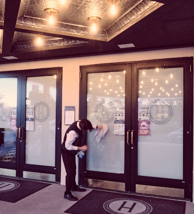 woman in white shirt standing near glass door