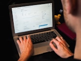 person using macbook pro on black table