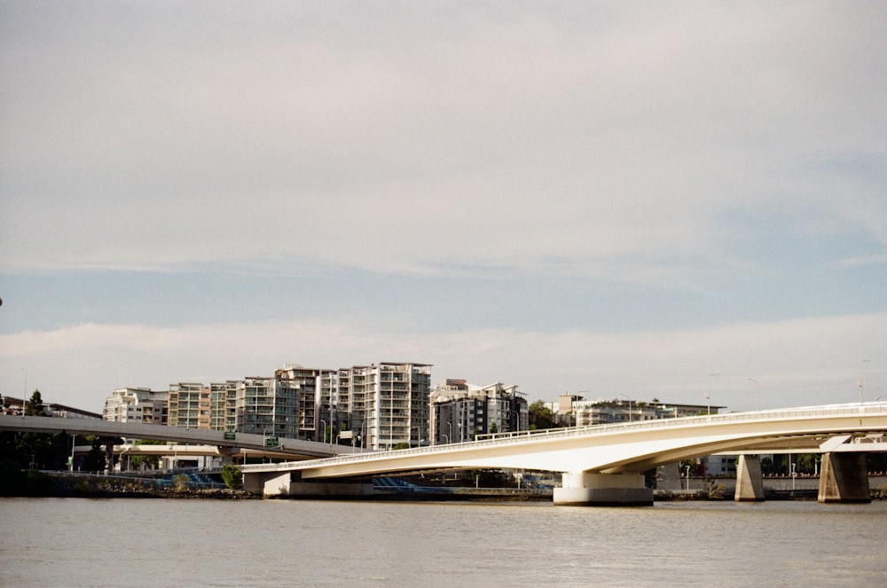 white bridge over body of water near city buildings during daytime