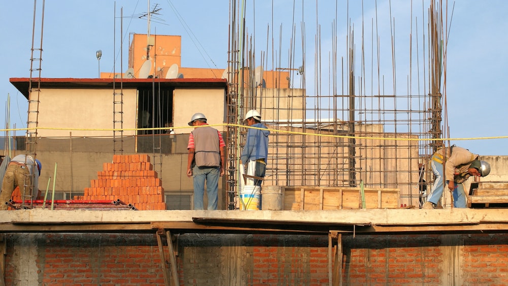 homem na jaqueta jeans azul de pé ao lado do homem na camisa cinza