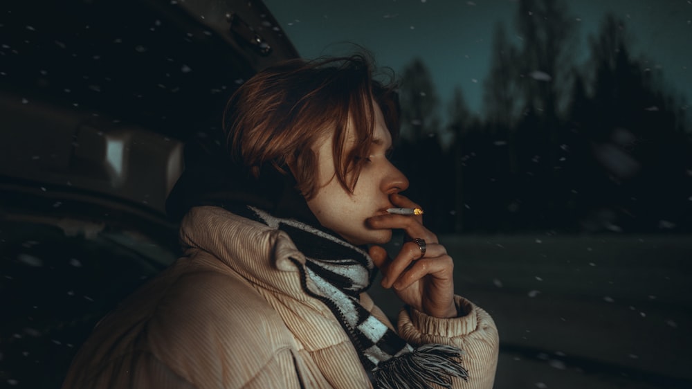 woman in brown jacket smoking cigarette