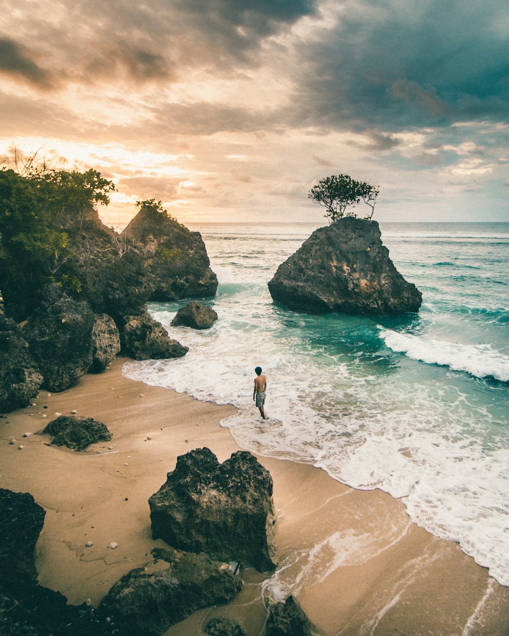 woman in white shirt and black pants standing on seashore during daytime