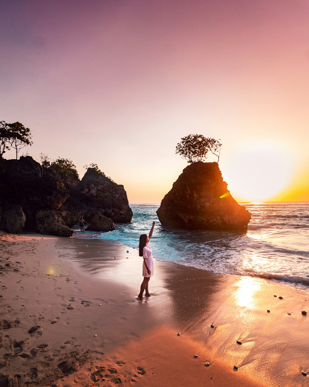 woman in white dress walking on beach during sunset