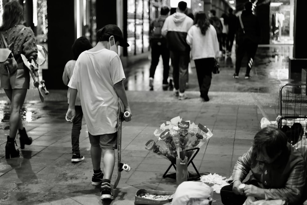 man in white t-shirt and black pants holding umbrella walking on street