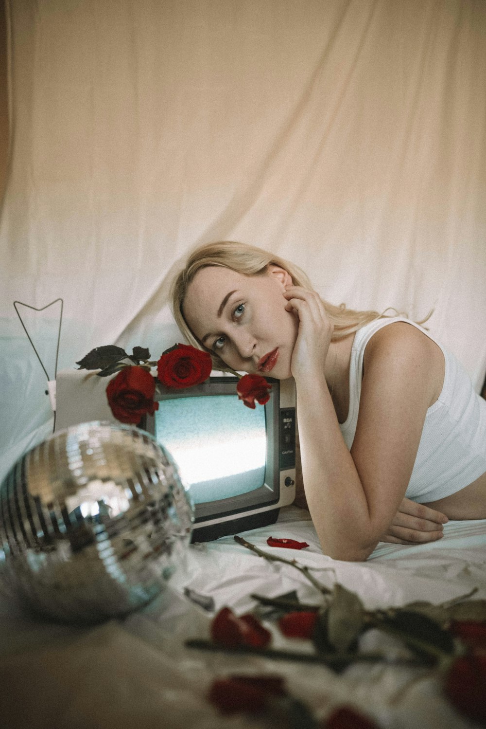 woman in white tank top lying on bed