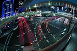 Futuristic digital overlays showing traffic flows on busy urban streets at dusk.