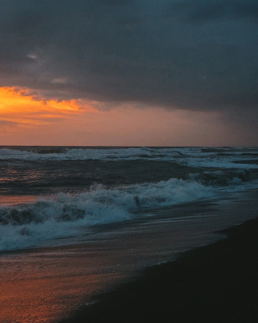 Olas del océano rompiendo en la costa durante la puesta de sol