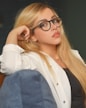 woman in white long sleeve shirt and blue denim jeans wearing black framed eyeglasses