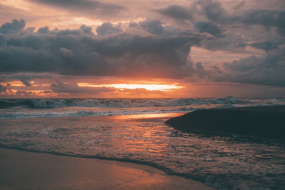 Meereswellen, die bei Sonnenuntergang an Land stürzen