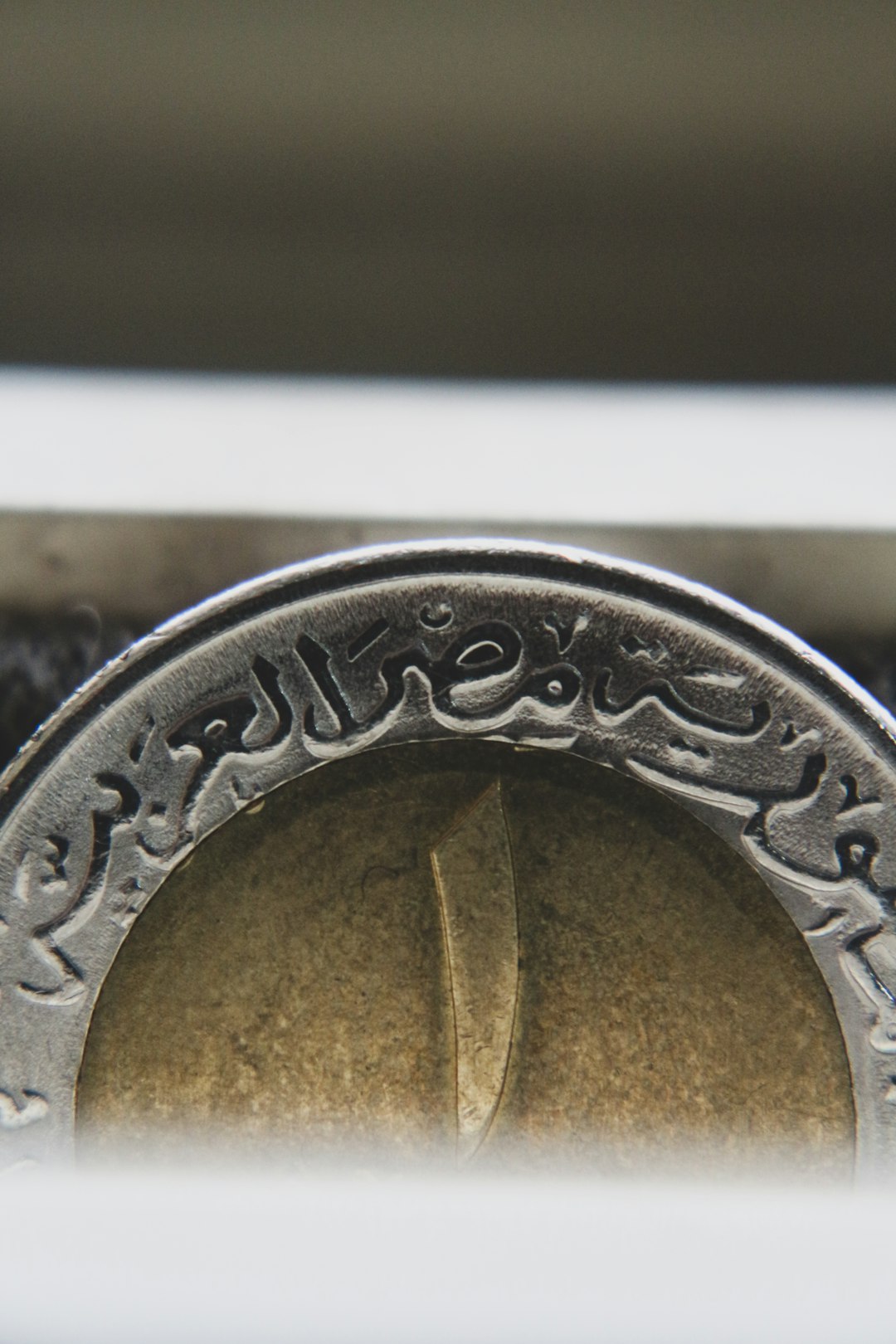 gold round coin on white surface