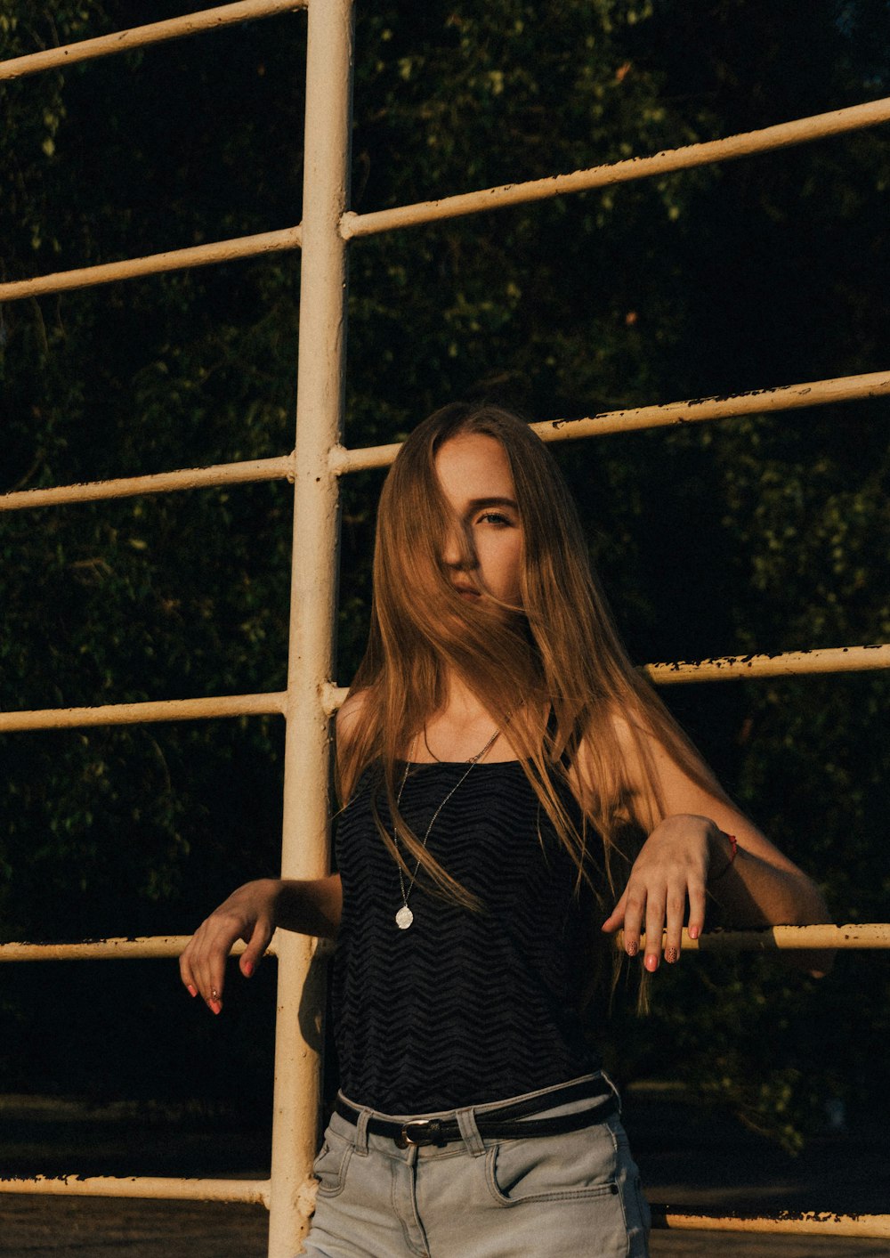 woman in black and white striped long sleeve shirt standing beside brown wooden fence during daytime