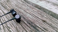 Compact and portable in-ear headphones displayed on a wooden surface.