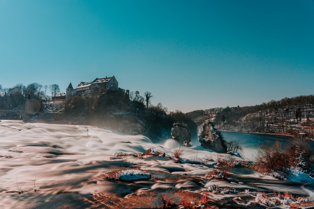 snow covered mountain near body of water during daytime