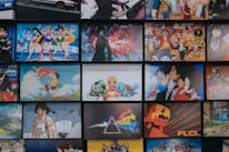 A collection of animated posters arranged in a grid pattern. The images include a mix of famous anime characters, scenes from animated shows, and iconic artwork. Characters from popular series such as Pokémon, Sailor Moon, One Piece, and others are prominently displayed. The overall scene gives off a vibrant and colorful atmosphere.