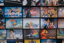 A collection of animated posters arranged in a grid pattern. The images include a mix of famous anime characters, scenes from animated shows, and iconic artwork. Characters from popular series such as Pok&eacute;mon, Sailor Moon, One Piece, and others are prominently displayed. The overall scene gives off a vibrant and colorful atmosphere.